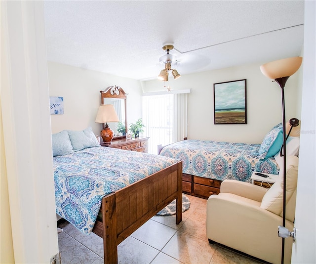 tiled bedroom featuring ceiling fan and a textured ceiling