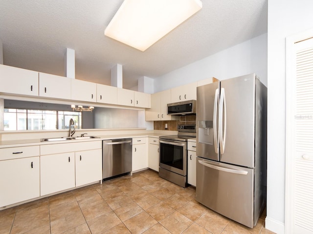 kitchen featuring sink, white cabinets, stainless steel appliances, and a textured ceiling