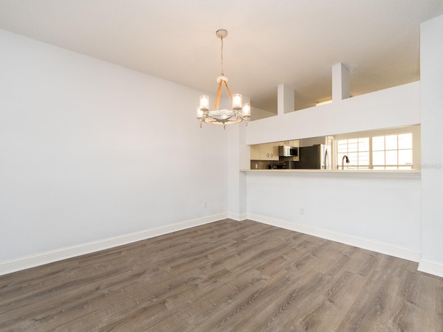 spare room with dark hardwood / wood-style flooring, a chandelier, and sink