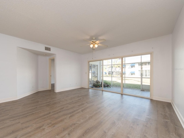 empty room with ceiling fan, a textured ceiling, and hardwood / wood-style flooring