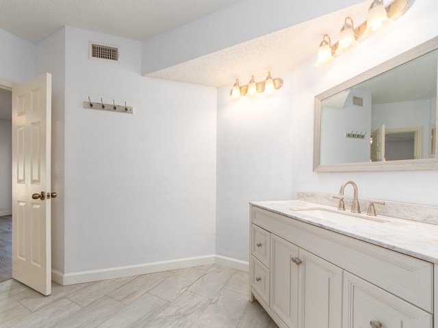 bathroom with vanity and a textured ceiling