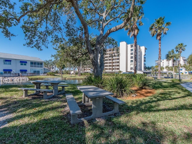 surrounding community with a lawn and a water view