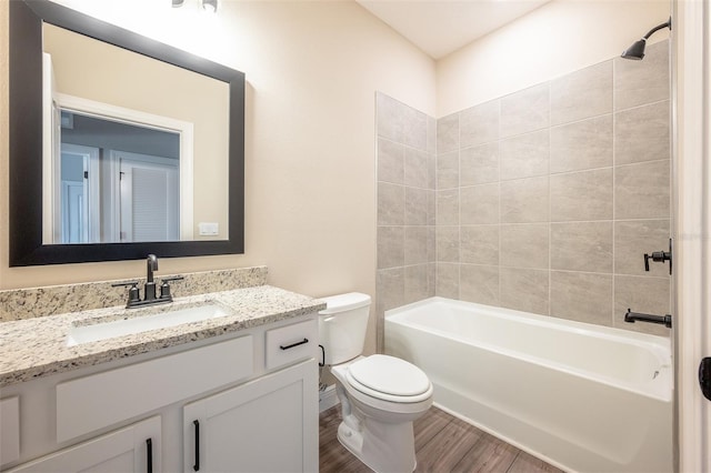 full bathroom featuring hardwood / wood-style floors, vanity, toilet, and tiled shower / bath combo