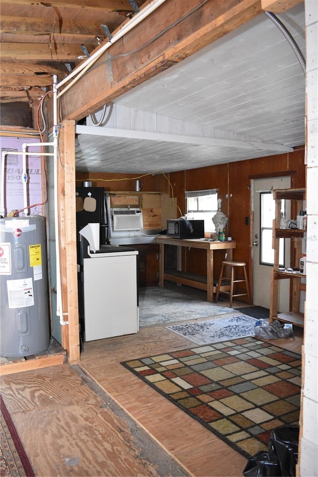 basement featuring hardwood / wood-style floors, wood walls, and water heater