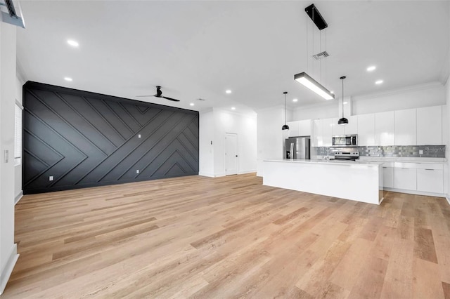 unfurnished living room with ceiling fan, light wood-type flooring, and ornamental molding