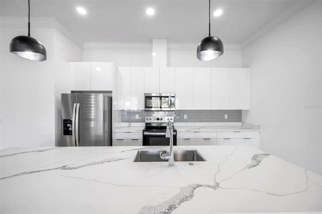 kitchen with crown molding, appliances with stainless steel finishes, and pendant lighting