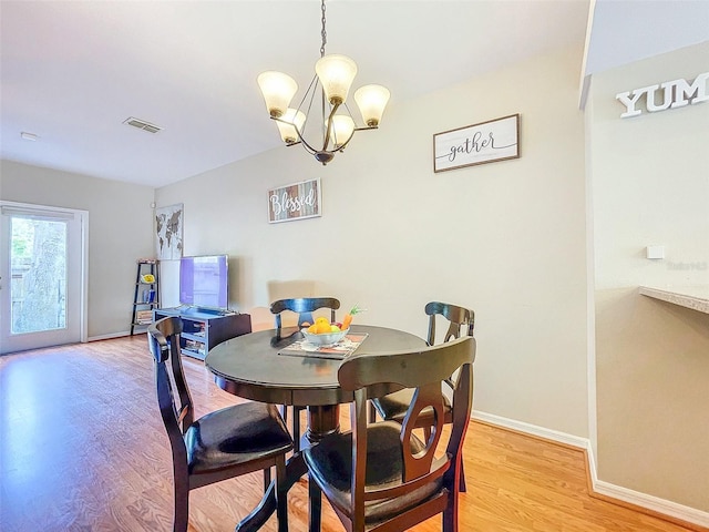 dining space with a chandelier and light hardwood / wood-style flooring