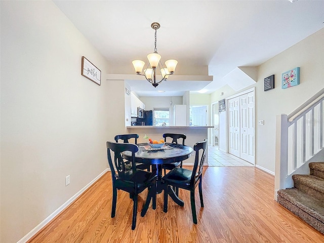 dining area featuring light hardwood / wood-style floors and an inviting chandelier