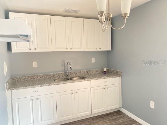 kitchen with extractor fan, white cabinetry, dark wood-type flooring, and sink