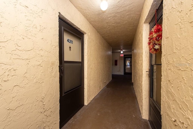 hall featuring a textured ceiling