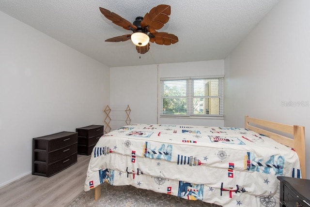 bedroom featuring a textured ceiling, light hardwood / wood-style floors, and ceiling fan