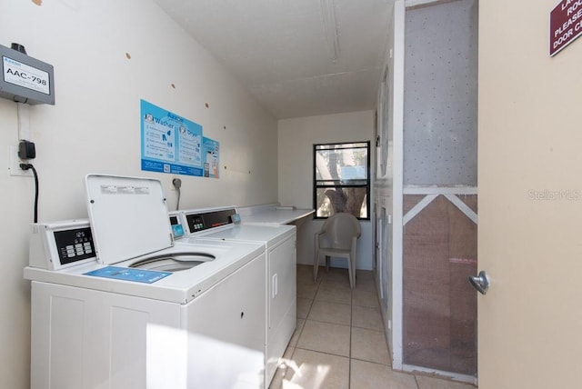 laundry area featuring washer and dryer and light tile patterned floors