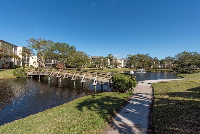 dock area with a lawn and a water view