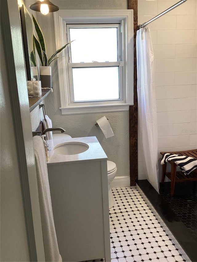 bathroom featuring a shower with curtain, vanity, and toilet