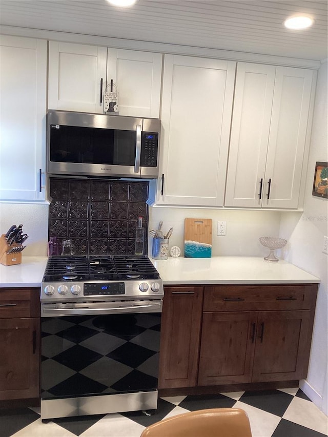 1529 Paloma Ln, Dunedin, FL 34698 - kitchen featuring appliances with stainless steel finishes, light countertops, white cabinetry, backsplash, and tile patterned floors