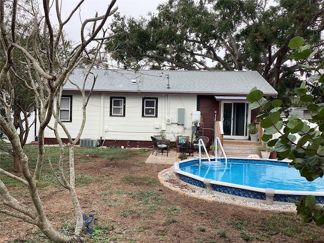 1529 Paloma Ln, Dunedin, FL 34698 - back of property featuring an outdoor pool, a patio, central AC, and roof with shingles
