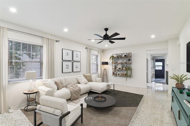 living room featuring light speckled floor, baseboards, a ceiling fan, and recessed lighting