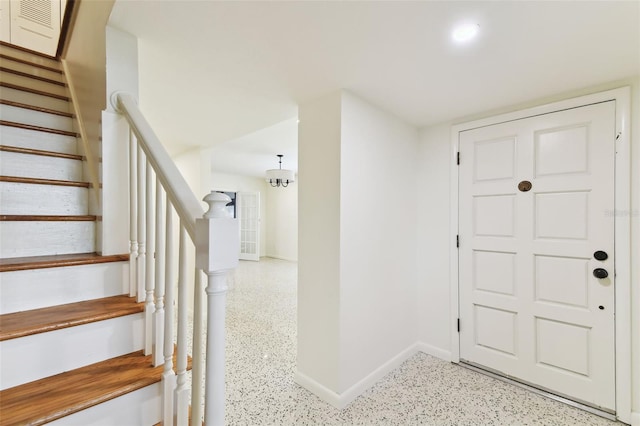 entrance foyer with light speckled floor, stairway, and baseboards