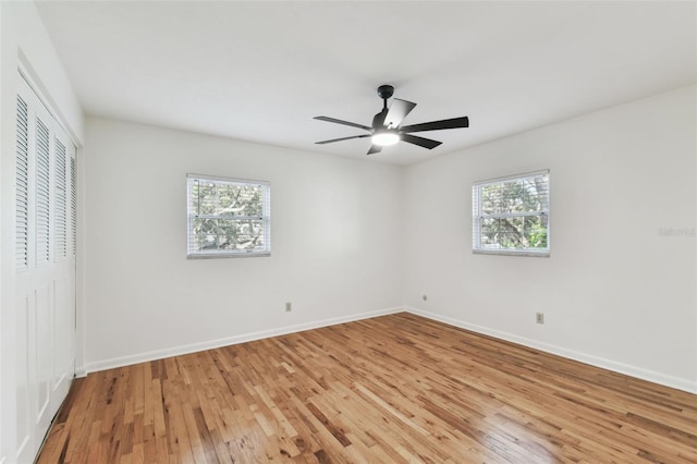 unfurnished room featuring baseboards, ceiling fan, a wealth of natural light, and light wood-style floors