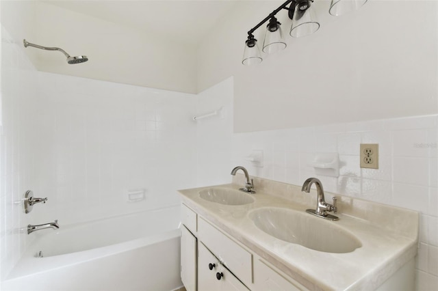 full bathroom featuring double vanity, tile walls, tub / shower combination, and a sink