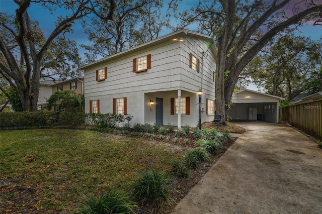 view of front of home with a yard, brick siding, concrete driveway, and fence