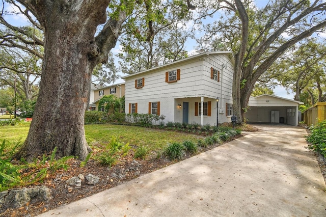 view of front of home featuring a carport, driveway, brick siding, and a front yard