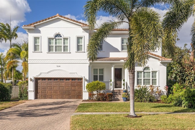 mediterranean / spanish-style house with a front lawn and a garage