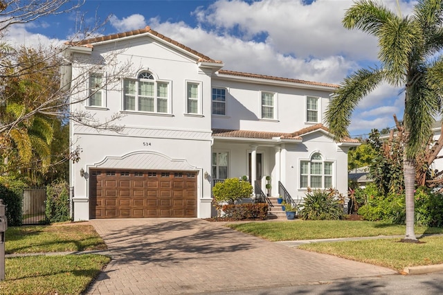 mediterranean / spanish house with a front yard and a garage