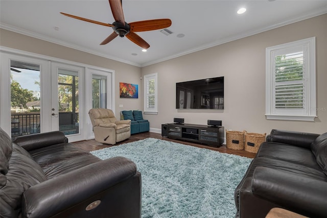 living room with a healthy amount of sunlight, crown molding, and dark wood-type flooring