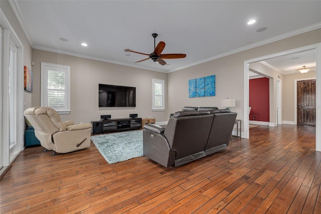 living room with ornamental molding, hardwood / wood-style flooring, ceiling fan, and a healthy amount of sunlight