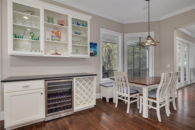 dining room featuring dark hardwood / wood-style floors, wine cooler, a healthy amount of sunlight, and crown molding