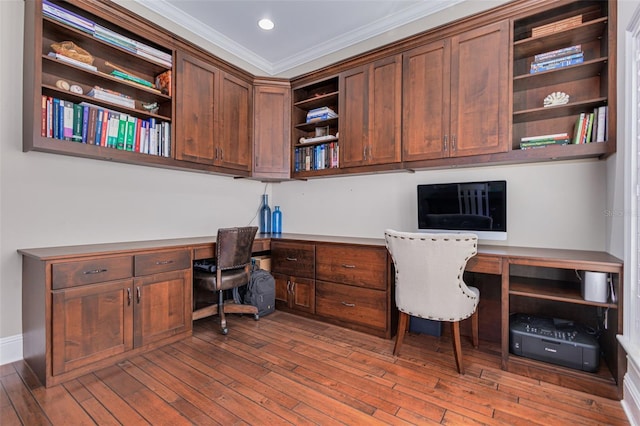 office with hardwood / wood-style floors, built in desk, and crown molding