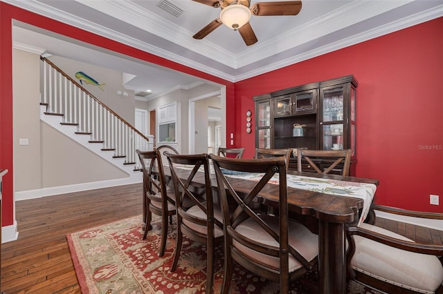 dining space featuring dark hardwood / wood-style floors, ceiling fan, and crown molding