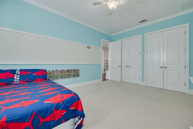 carpeted bedroom featuring ceiling fan, ornamental molding, and two closets