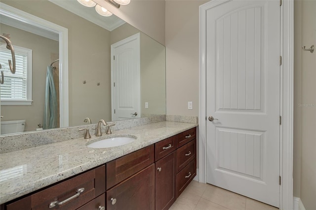 bathroom with tile patterned floors, vanity, toilet, and crown molding