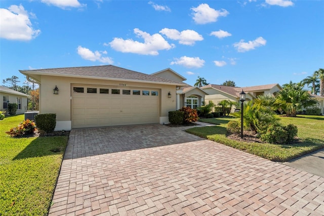 ranch-style house featuring a front yard, central air condition unit, and a garage