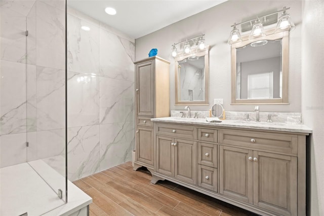 bathroom featuring tiled shower and vanity