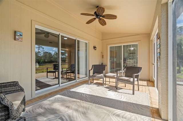 sunroom featuring ceiling fan and vaulted ceiling