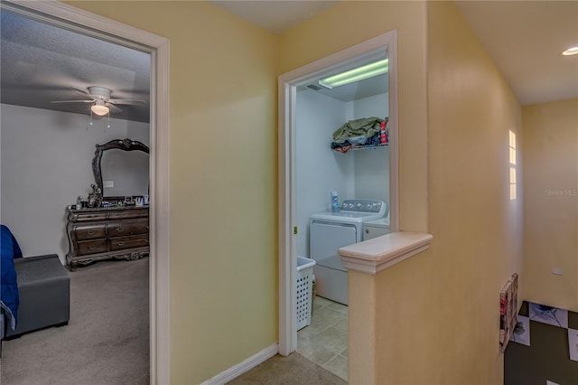 hall with washer and clothes dryer and light colored carpet