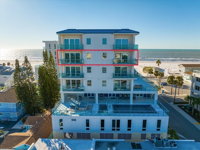 view of property with a water view and a view of the beach