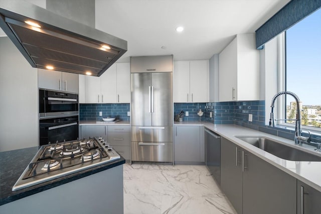 kitchen featuring sink, stainless steel appliances, range hood, gray cabinets, and decorative backsplash