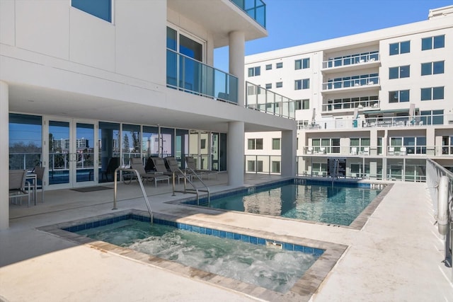 view of swimming pool featuring a patio and a hot tub