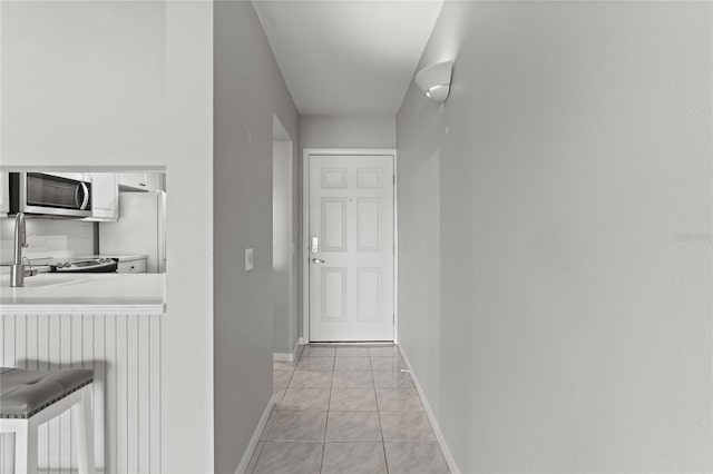 hall with light tile patterned floors and sink