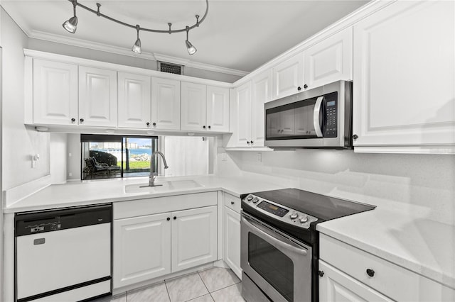 kitchen featuring sink, crown molding, track lighting, white cabinets, and appliances with stainless steel finishes