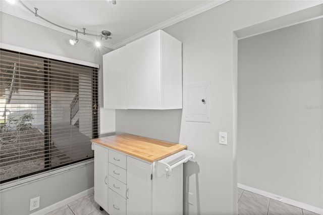 interior space with light tile patterned floors and ornamental molding