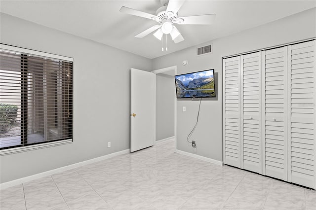 unfurnished bedroom featuring ceiling fan and a closet