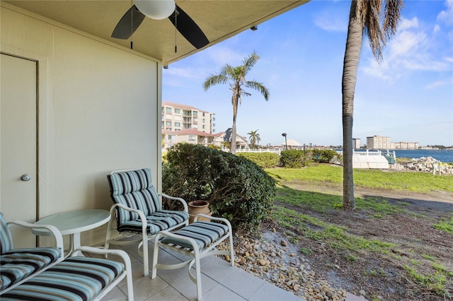 view of patio with ceiling fan and a water view