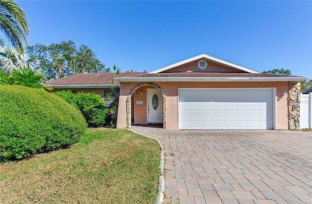 ranch-style home with a garage and a front lawn