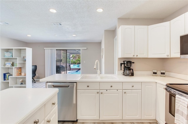 kitchen featuring white cabinets, sink, appliances with stainless steel finishes, and a textured ceiling