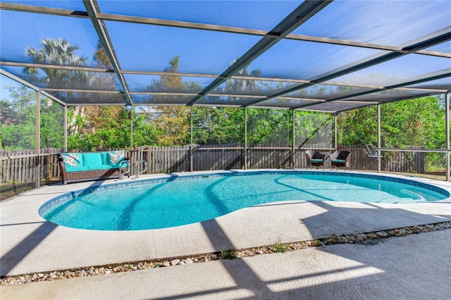 view of swimming pool featuring glass enclosure